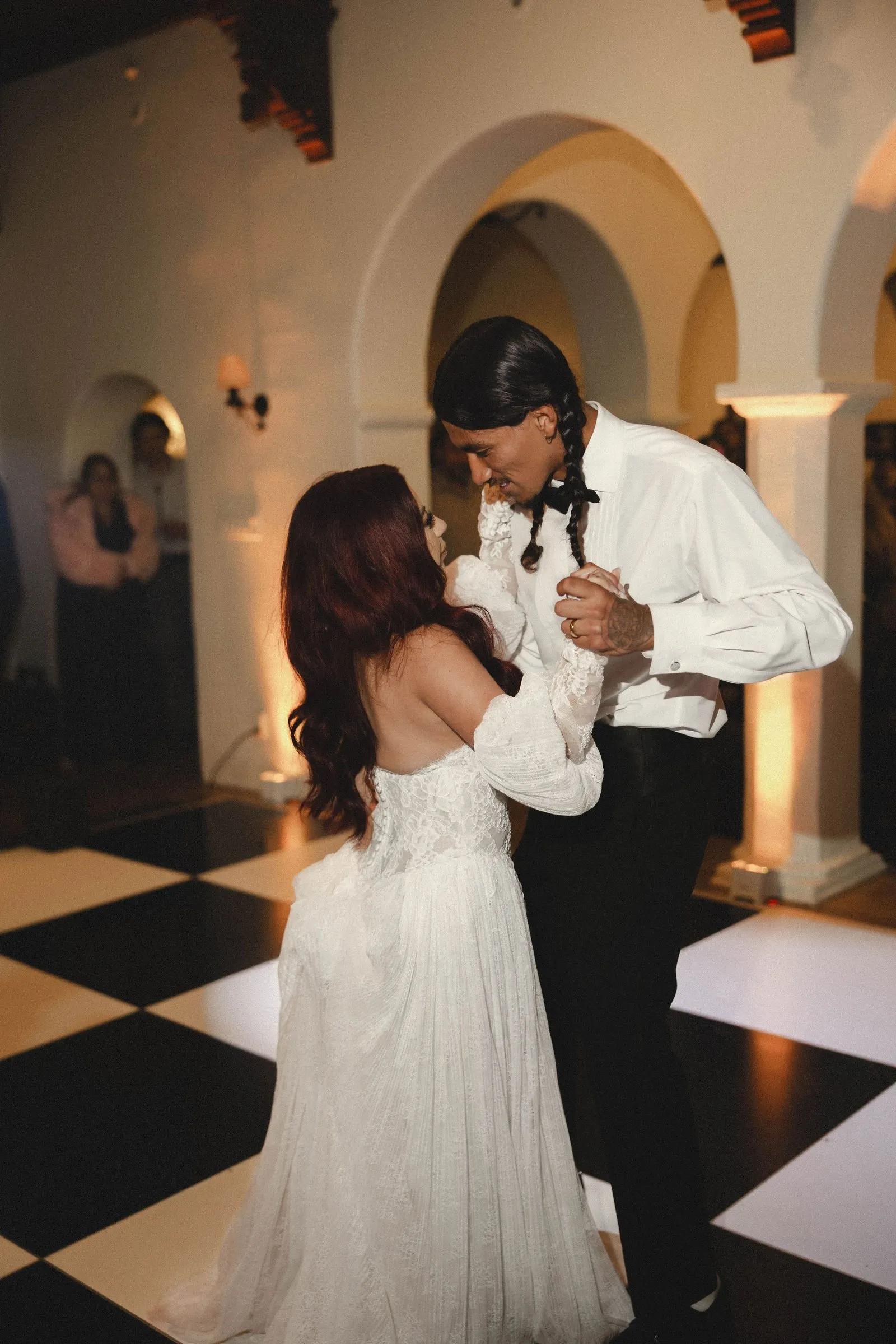 Bride and groom share their first dance on the black-and-white checkered floor of Casa Romantica's historic great room in San Clemente.