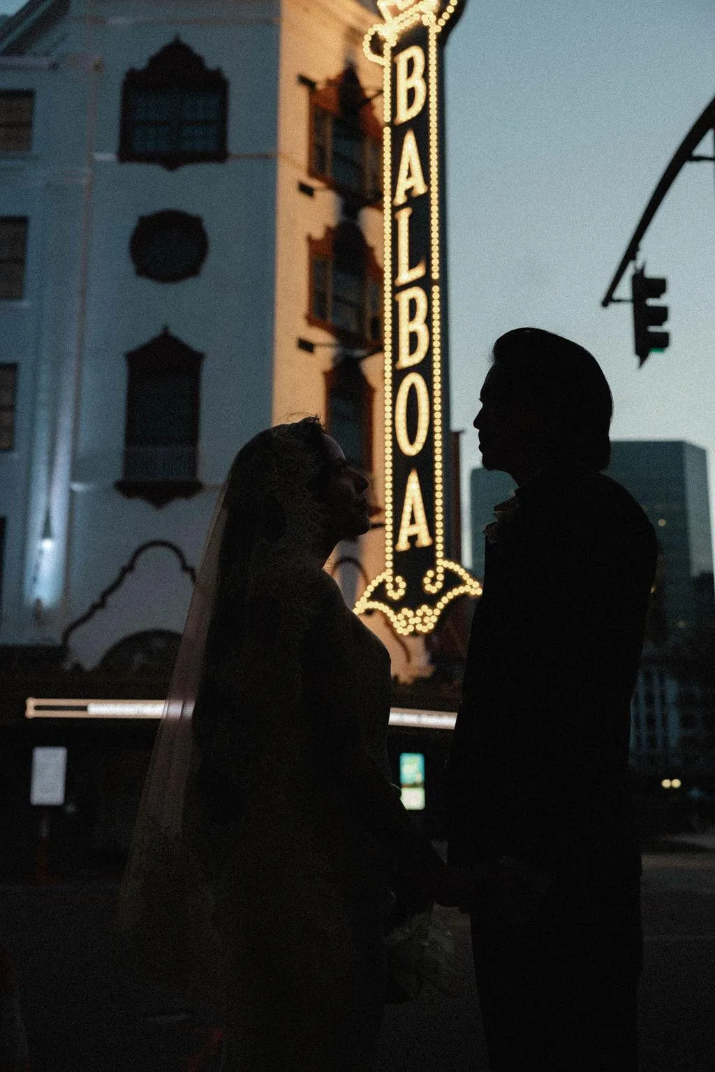 Leslie and Richard beneath the Balboa Theatre marquee at dusk in downtown San Diego.